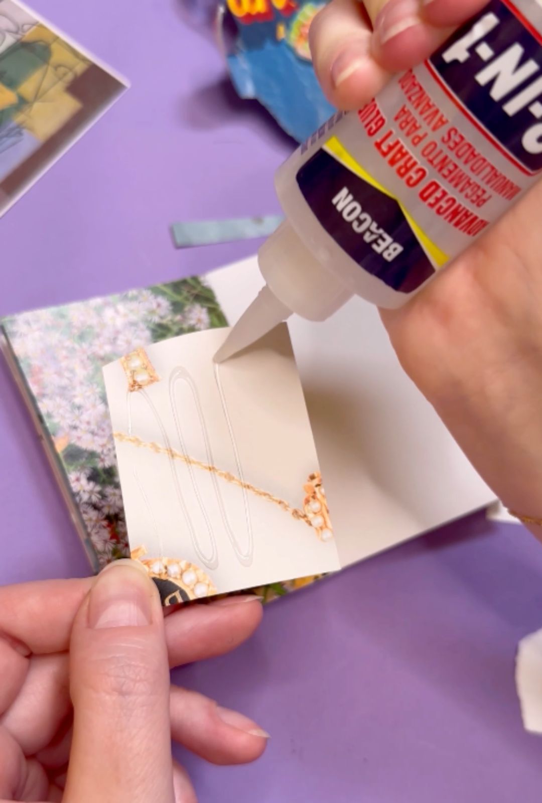 Left hand is holding a piece of paper. The right hand is holding a bottle of beacon's 3-in-1 glue and squeezing it out onto the paper.